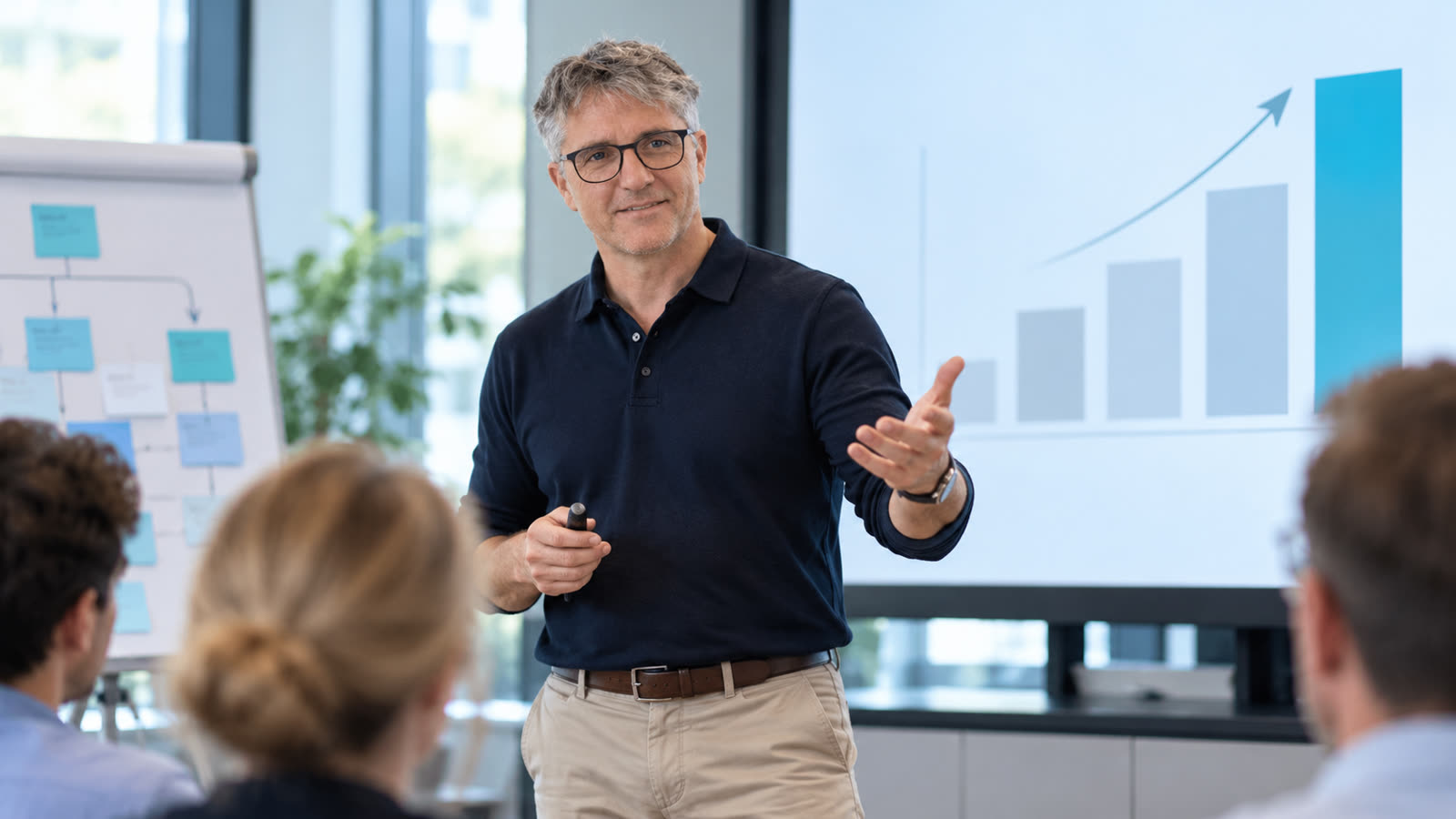 Trainer präsentiert vor einer Gruppe, im Hintergrund ein Balkendiagramm